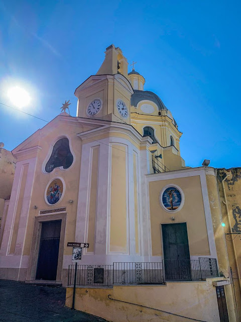Church of Santa Maria delle Grazie in Piazza dei Martiri, Procida a church with bell tower with yellow facade and white decorative elements