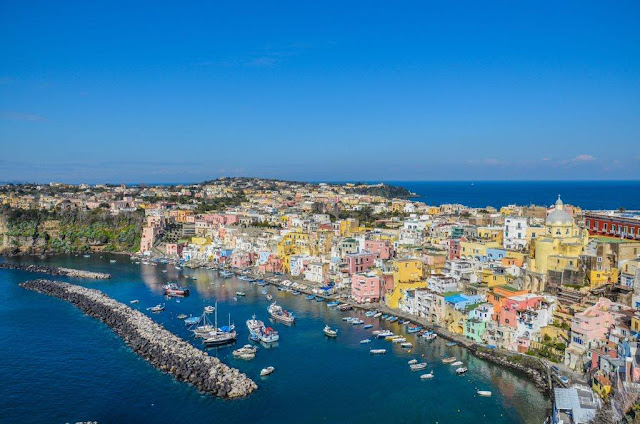 La Corricella view from Terra Murata old houses of pastel color belonged to fishermen boats and sea panorama