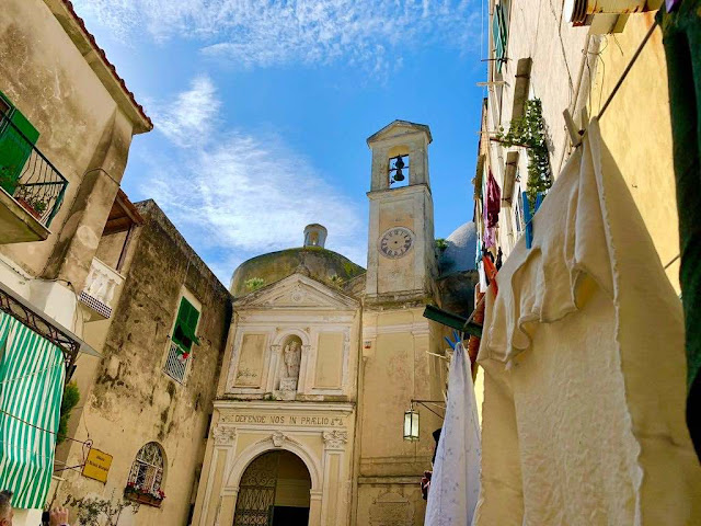 Abbey of St.Michael in Procida island a small abbey with its bell tower inside a narrow alley where from a terrace clothes are laid to dry